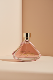 Pink and gold Tres Jour perfume bottle on a white background