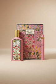 Gucci Flora perfume set with floral design on a pink background
